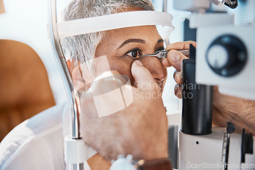 Image of Help, hands or senior woman in eye exam with doctor eyesight at optometrist or ophthalmologist. Optician helping a mature customer testing or checking vision, iris or retina visual health in office