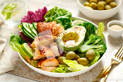 Image of Salmon avocado bowl with broccoli, olives and fresh salad. Healthy food, keto diet
