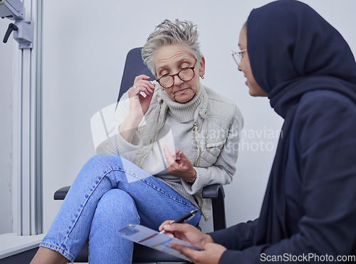 Image of Optometry, healthcare and woman filling in a form before doing a eye test in a optic clinic. Health insurance, ophthalmology and optician helping senior female patient with document in optical store.