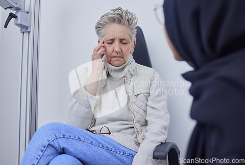 Image of Blind, headache and optometry with a senior woman patient in an optician office for a test or eye exam. Doctor, pain and medical with a mature female sitting at the optometrist for visual impairment