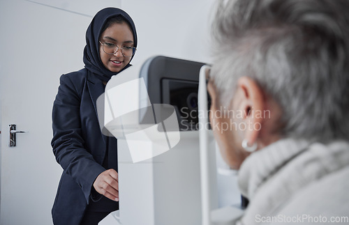 Image of Optometrist, muslim woman and testing eyesight health in optometry lab with optical machine indoors. Senior patient in eye clinic, person at appointment to scan diagnosis and ophthalmologist working
