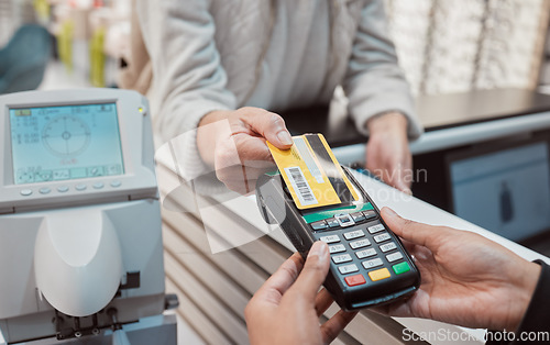 Image of Hands, credit card and machine for payment, ecommerce or banking transaction at clinic or store. Hand of customer tapping debit in transact for purchase, electronic pay or POS at optometry shop