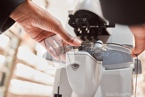 Image of Hands, glasses and vision with an optometrist working in a clinic to configure frame prescription lenses. Healthcare, blind and eyewear with an optician at work to improve eyesight with spectacles