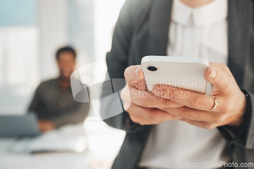 Image of Hands, business phone and typing in office, texting or social media in company workplace. Technology, cellphone and woman or female entrepreneur with mobile smartphone for networking or web browsing.