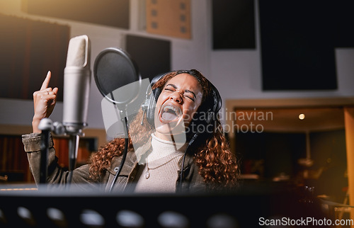 Image of Music, singing and radio with a black woman celebrity at her record label to sing a song for her new album. Creative, art and performance with a female singer streaming live in a recording studio