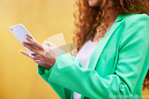 Image of Woman, phone and hands typing on yellow background for communication, social media and tech chat. Closeup model, smartphone and network connection for mobile app, digital contact and search website