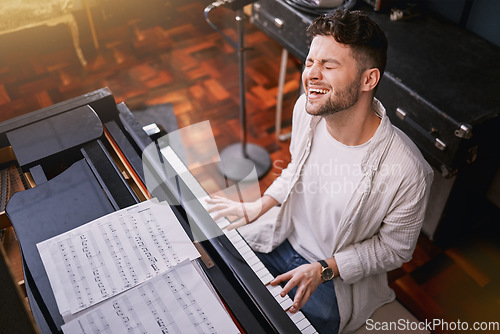 Image of Top view, piano and man singing, creative and training for performance, show or talent. Male artist with skills, recording studio or singer with keyboard, vocal practice or playing musical instrument