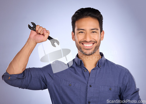 Image of Portrait of man holding wrench isolated on studio background for repair solution, maintenance or plumbing. Professional worker, asian person or happy plumber with mechanic tools hand in job success
