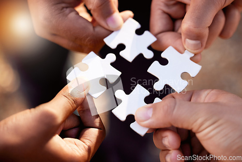 Image of Group hands with puzzle for solution, teamwork and workflow goals, achievement and success in closeup. Team building game, project development and people for problem solving, synergy or collaboration