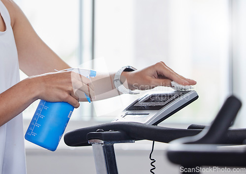 Image of Sanitizer, disinfect and fitness person cleaning gym surface before exercise, workout and training for health and wellness. Hygiene, wipe and anti virus on a treadmill by hand spray equipment clean