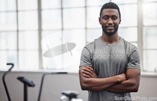 Image of Happy black man smile in gym with arms crossed for training, exercise or workout in Nigeria. Portrait of strong bodybuilder, personal trainer and male in fitness club for coaching, sports or wellness