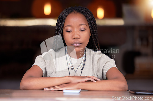 Image of Depression, sad and woman with phone in coffee shop during breakup or fight on her cellphone. Depressed, moody and unhappy African female with mental health problem with mobile after argument in cafe