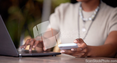 Image of Black woman, hands and laptop with phone for communication, social media or chatting on table. Hand of African American female freelancer in remote work on computer and smartphone in multitasking