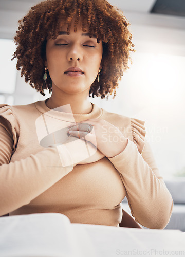 Image of Black woman, prayer and hands on heart with eyes closed to meditate in home. Praying, spiritual chest and meditation of calm female feeling love, faith and worship for God, Jesus and Holy Spirit.