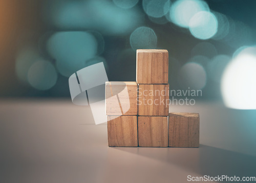 Image of Building, business and blocks for investment, finance and growth on a table. Accounting, education and conceptual structure for profit, planning and investing in steps for progress on a desk