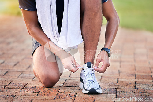 Image of Closeup, outdoor and man with training, shoelace and workout for marathon, cardio and wellness. Zoom, male athlete and runner with sneakers, tying shoes or practice for performance, energy or balance