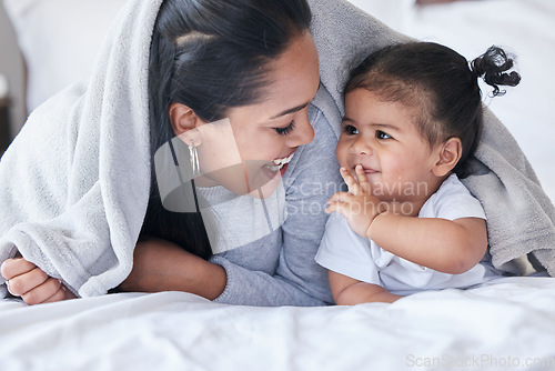 Image of Mother, child and baby playing with woman bonding in a bed with blanket laughing being funny together in a bedroom or room. Mom, kid and single parent in a home or house with little daughter