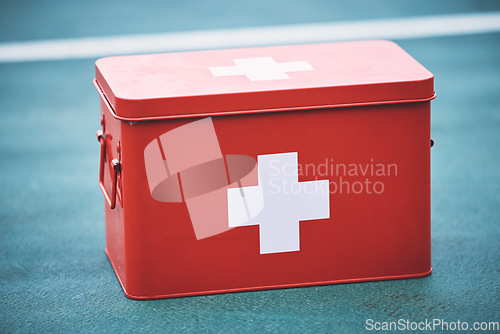 Image of First aid, kit and health equipment for medical emergency, response and treatment kit isolated on a blurred background. Red, cross and medicine on a sports ground or court for fast health or cure