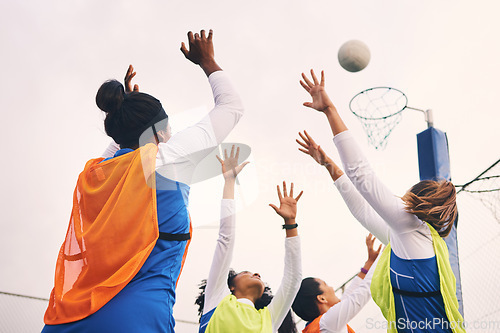 Image of Netball, goal shooting and fitness of a girl athlete group on an outdoor sports court. Aim, sport game and match challenge of a black person with a ball doing exercise and training in a competition