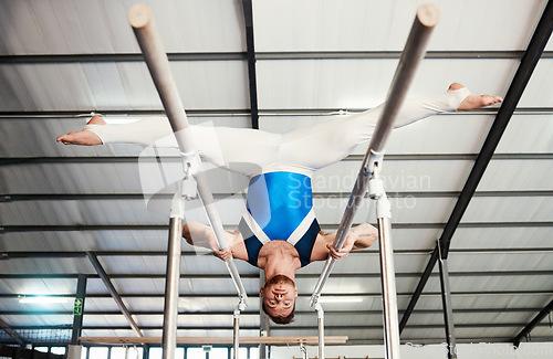 Image of Gymnast man, bars and exercise with balance, strong body and focus for sports, vision and split legs in air. Gymnastics, athlete and training with muscle development, workout and low angle at gym