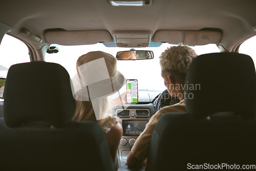 Image of Rear view of a mixed race man and caucasian girlfriend in a car, travel using a smartphone gps to navigate their way to a location while sitting in a vehicle and couple road trip together in Canada