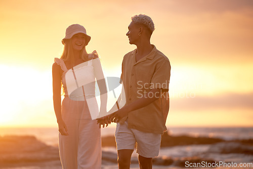 Image of Closeup portrait of an young affectionate mixed race couple standing on the beach and smiling during sunset outdoors. Hispanic man and caucasian woman showing love and affection on a romantic date at