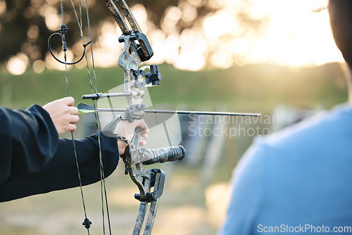 Image of Archery, closeup and target training with an instructor on field for hobby, aim and control. Arrow, practice and archer people together outdoor for hunting, precision and weapon, shooting competition