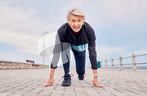 Image of Senior woman, starting position and running outdoor at beach promenade, runner exercise or sky mockup. Elderly lady ready to run, cardio and fitness training for mindset of sports, marathon or energy