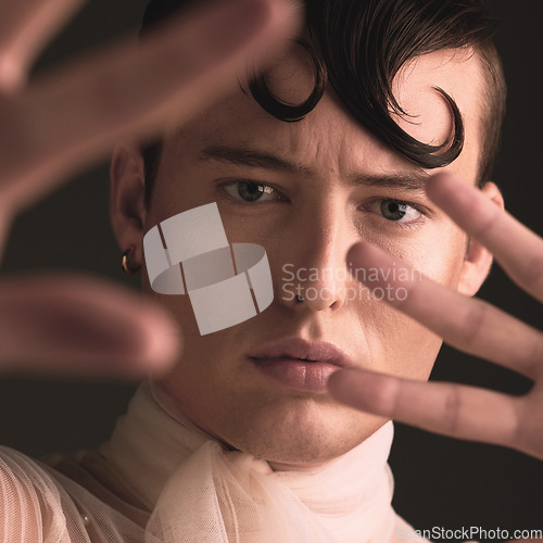 Image of Beauty portrait of transgender man isolated on dark background for creative and queer fashion aesthetic. Young lgbtq model or gay person face with cosmetics, makeup and hands for art style in studio