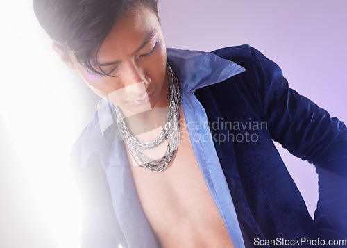 Image of Stylish, edgy and cyberpunk man with fashion isolated on a purple studio background. Creative, futuristic and serious Asian guy with expression through clothes, style and fashionable on a backdrop