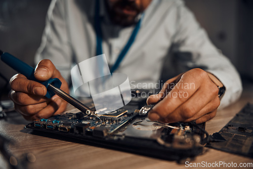 Image of Man hands, it or soldering motherboard in engineering workshop for night database fixing. Zoom, technician or circuit board tools in repair, maintenance or upgrade in information technology industry