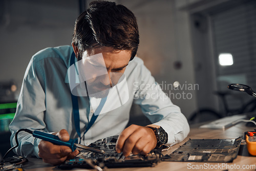 Image of Concentration man, it or soldering motherboard in engineering workshop for night database fixing. Technician, circuit board or tools in repair, maintenance upgrade or information technology industry