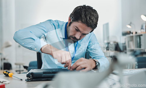 Image of Laptop, repair and concentration with an engineer or handyman fixing hardware in an IT office. Computer, information technology or maintenance with a male service professional at work on electronics