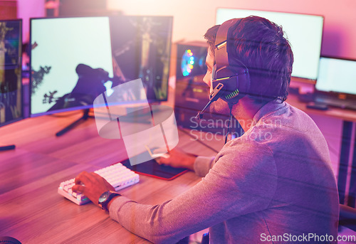 Image of Computer gaming, man and headphones for esports, online games or virtual competition in dark room. Gamer guy, digital player and live streaming on headset in neon lighting, technology or rpg streamer