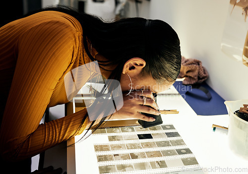 Image of Woman, photographer and magnifying glass for film negatives, zoom and analysis for photo journalist job. Photography expert, analyse picture and focus in studio for choice, decision and creativity