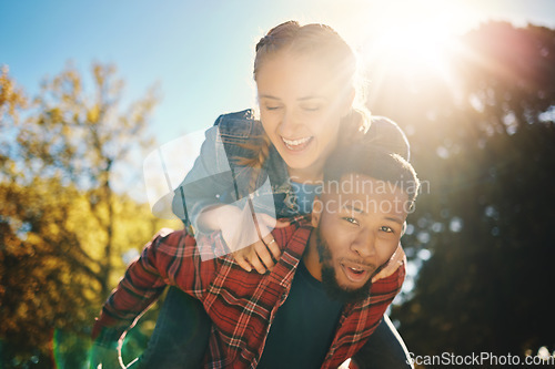 Image of Interracial couple, sunshine and piggyback in park, summer and outdoor date together for happiness, smile and nature. Happy man carrying woman in garden for love, care and relax for diversity partner