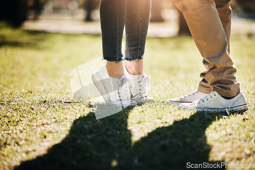 Image of Shoes, grass and love with a couple outdoor together, kissing for romance, dating or affection in summer. Nature, field or feet with a man and woman on a romantic date for relationship bonding