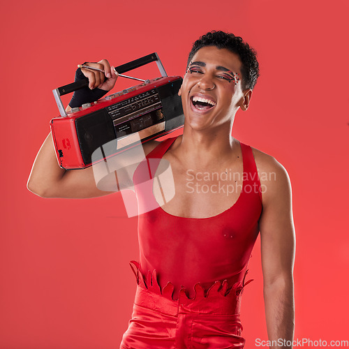 Image of Happy, man and boombox radio in studio for gay, pride and vogue aesthetic with retro 80s tech by red background. Lgbtq model, vintage fashion and music with happiness, listening and comic laughing