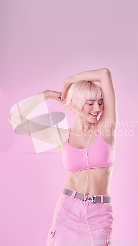 Image of Fashion, dance and woman isolated on pink background listening to music with cosmetics and pastel aesthetic. Happy, gen z model or person dancing with audio for fun, freedom and self love in studio