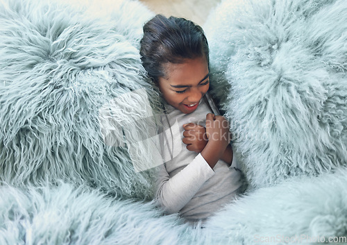 Image of Comfy, happy and girl on a pillow to relax, playing and laughing from above in a house. Smile, laughing and carefree child cozy in the lounge being playful, funny and relaxing on a soft sofa