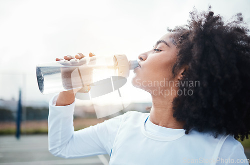 Image of Black woman, sports and drinking water at court during training, workout and sport exercise outdoors. Fitness, thirsty and girl with bottle for wellness, hydration and recovery during practice