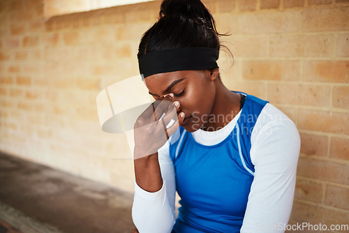 Image of Headache, fitness and black woman in pain during run, exercise or workout against brick wall background. Sports, migraine and girl suffering with ache, discomfort and fatigue during cardio routine