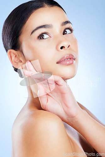 Image of Skincare, woman and hand on face in studio for beauty, wellness and cosmetic grooming on blue background. Skin, glow and girl model relax with smooth, soft and dermatology satisfaction while isolated