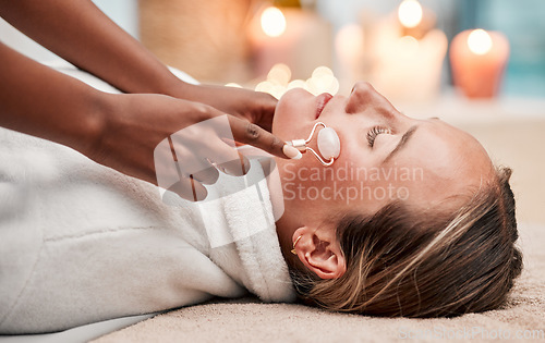 Image of Face massage, roller and woman at spa with therapist, treatment and skincare, self care and rose quartz. Holistic therapy at luxury resort, healthy skin and wellness, hands and massaging with beauty