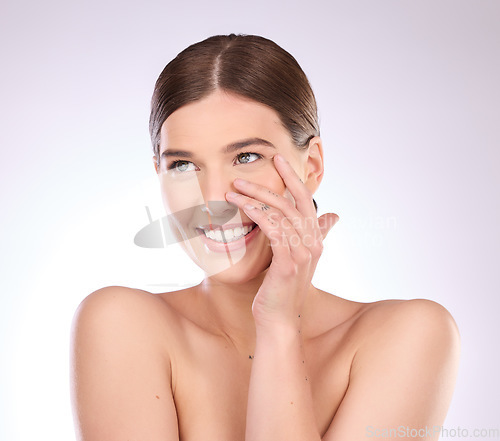 Image of Skincare, woman and touch face in studio for beauty, dermatology or wellness cosmetics on background. Happy female model, smile and aesthetic glow of shine, laser transformation or facial spa results