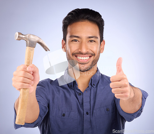 Image of Man, studio and portrait with thumbs up and hammer for handyman, maintenance or repair work with smile. Happy asian model person on purple background for engineer, mechanic or technician job tools