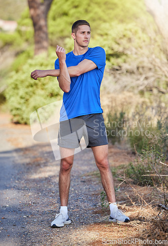 Image of Stretching arms, fitness and man in nature getting ready for running, exercise or training. Sports health, thinking and male athlete warm up or prepare to start cardio, exercising or jog for wellness