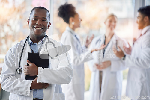 Image of Black man, doctor portrait and tablet with medical team in hospital ready for healthcare work. Wellness, health and medic employee in a clinic feeling happiness and success with blurred background