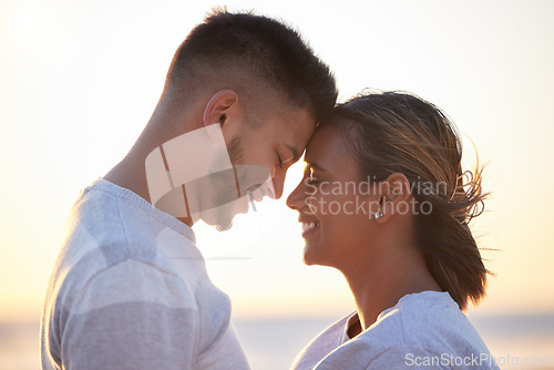 Image of Couple, sunset forehead touch for love, outdoor beach date and happy holiday together. Man, woman and face of relationship at ocean for freedom, support and relax with trust, peace and smile of care