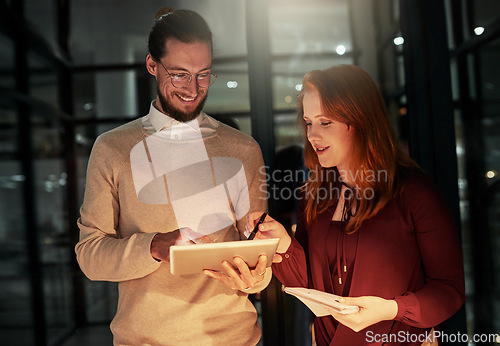 Image of Businessman, tablet and office in night with woman, planning or web design for iot, writing or team strategy. Happy teamwork, it goal and ux designer group for idea, vision or dark workplace for data